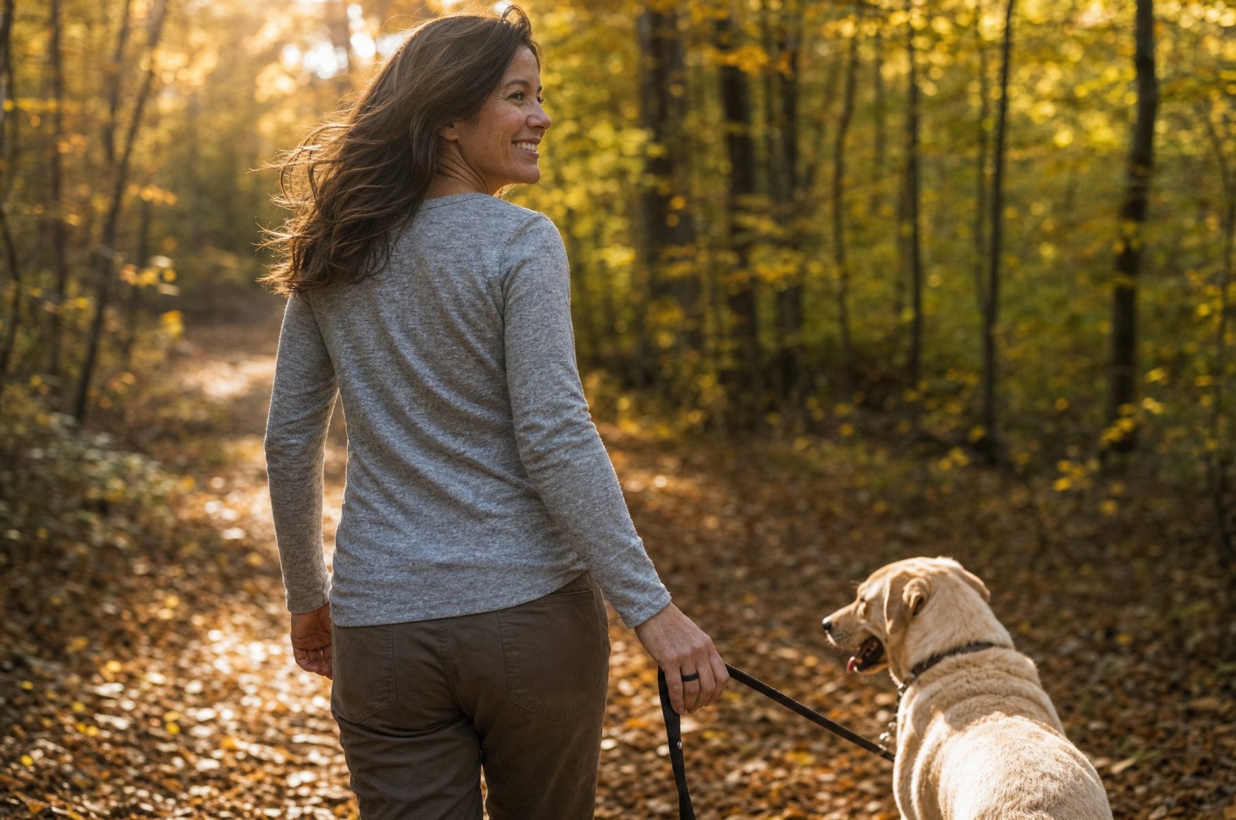 Frau geht mit Labrador im Wald spazieren, SOLID RING am Finger